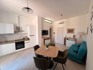 a living room with a table and a blue couch at MESSAPIA HOME Apartments in Mesagne