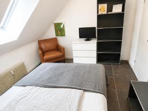 a attic bedroom with a bed and a chair at Manjana`s Waldblick in Braunlage