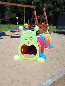 a playground with a play equipment in the sand at Apartamenty W Zaciszu in Kamienica Królewska
