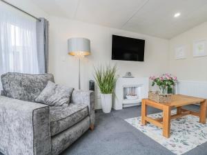 a living room with a couch and a table at The Cotswold Holiday Lodge in Evesham