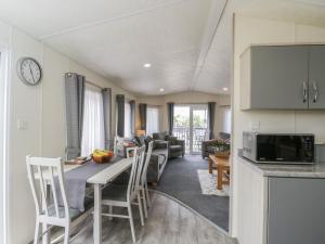 a kitchen and living room with a table and chairs at The Cotswold Holiday Lodge in Evesham