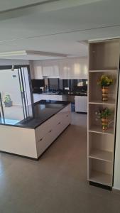 a kitchen with white cabinets and two potted plants at Villa Sereine in Sidi Yahia