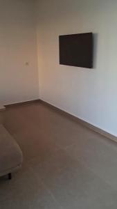 an empty room with a couch and a painting on the wall at Villa Sereine in Sidi Yahia