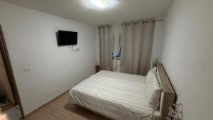 a bedroom with a bed and a flat screen tv at Modern Apartment in Arad