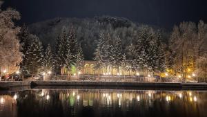 a building next to a body of water at night at Уютный дом в Джермуке in Jermuk