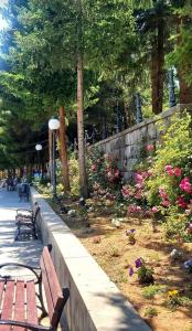 a park with benches and flowers and a stone wall at Уютный дом в Джермуке in Jermuk