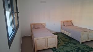 two beds in a small room with a window at Villa Sereine in Sidi Yahia +44 photos