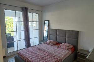 a bedroom with a bed and a large window at Logement au vauclin in Le Vauclin