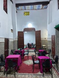 a room with purple tables and chairs and a mirror at Ryad Cherkaoui in Fez