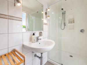 a white bathroom with a sink and a shower at Aqua Sands #2 - Stay Waiheke in Oneroa +6 photos