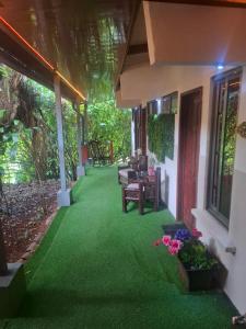 a porch of a house with green grass at ApartHotel Villa Pacande & Rooms in Alajuela