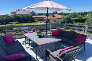 a patio with a table and chairs and an umbrella at Apartment in Dabrowa near the Sea in Gostyniec