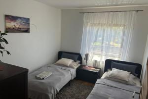 two beds in a room with a window at Apartment in Dabrowa near the Sea in Gostyniec