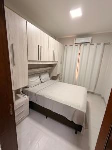 a small bedroom with a bed and cabinets at Apartamento Completo e confortável em Sinop Mt in Sinop