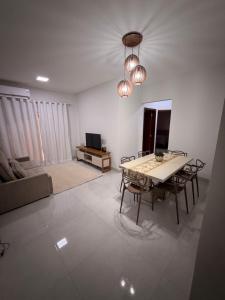 a living room with a table and chairs and a television at Apartamento Completo e confortável em Sinop Mt in Sinop