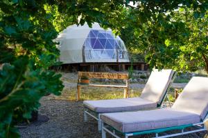 two chairs and a yurt in a garden at glamping giardino museo a gisa in Petralia Sottana