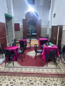 a room with tables and chairs with purple table cloth at Ryad Cherkaoui in Fez