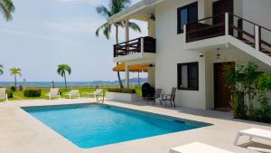 a villa with a swimming pool in front of a house at Pacific Beach 9 - Beachfront Condo, BBQ, pool, prime location, sleeps 4 in Potrero