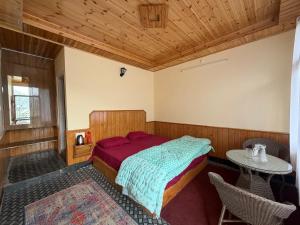 a bedroom with a bed and a table in it at Your Slow House in Shangarh