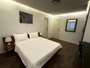a bedroom with a large white bed and a window at Melroseplace Complex in Bonabéri +4 photos