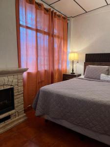 a bedroom with a bed and a fireplace and a window at Gran Bonanza Hotel in Alegría +19 photos