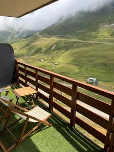 a chair and a table on a balcony with a mountain at Panorama à La Mongie in La Mongie