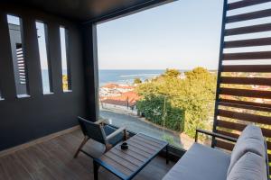 a living room with a table and a view of the ocean at CASA UNO Horizon in Platamonas