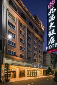 un edificio de hotel con un cartel delante en Ever Luck Hotel, en Kaohsiung