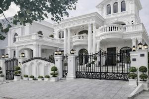 a white mansion with a black gate and fence at Hotel White Castle Islamabad in Islamabad