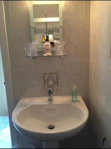 a white sink in a bathroom with a mirror at Lomond Villa in Balloch +5 photos