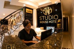 a man sitting at a counter with a laptop at House Studio Hotel in Bogotá