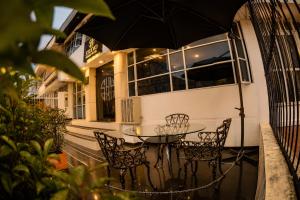 a table with chairs and an umbrella in front of a building at House Studio Hotel in Bogotá