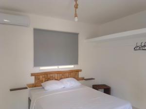 a bedroom with a white bed and a window at Macao Sky pool Suite in Punta Cana