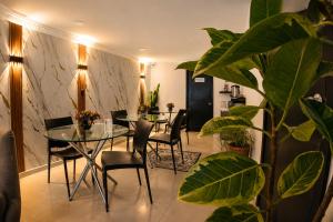 a dining room with a glass table and chairs at House Studio Hotel in Bogotá