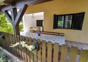 a porch with a table on a wooden fence at Kuća za odmor Na jezeru, Šoderica - Fenced Yard & Pet friendly holidayhouse in Legrad