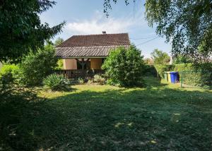 a house in a yard with a green yard sidx sidx sidx at Kuća za odmor Na jezeru, Šoderica - Fenced Yard & Pet friendly holidayhouse in Legrad