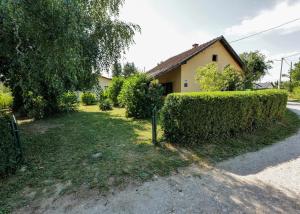 a house with a hedge in front of a yard at Kuća za odmor Na jezeru, Šoderica - Fenced Yard & Pet friendly holidayhouse in Legrad +18 photos