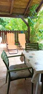 a table and chairs sitting on a patio at Kuća za odmor Na jezeru, Šoderica - Fenced Yard & Pet friendly holidayhouse in Legrad