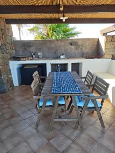 a wooden table and chairs on a patio at DAMMUSI IL CARRUBO in Pantelleria