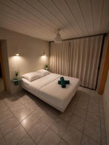 a bedroom with a bed with a green cross on it at Charmant T2 en RDC au centre de Figeac in Figeac +2 photos