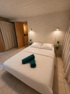 a large white bed with a blue towel on it at Charmant T2 en RDC au centre de Figeac in Figeac