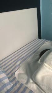 a close up of a bed with a pillow and sheets at Lavender Garden Kabarondo in Kayonza
