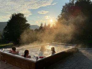 a group of people in a hot tub with steam at Chalupa Šťastný kopec in Deštné v Orlických horách