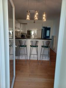 a kitchen with three bar stools in front of a counter at Betty in Saint-Gaudens
