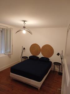 a bedroom with a bed with a black blanket and wooden floors at Betty in Saint-Gaudens