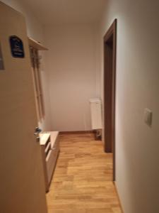 a room with a hallway with a door and wooden floors at Apartman Glorija in Brzeće