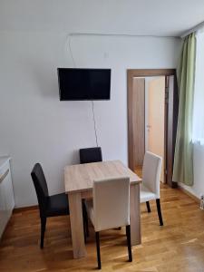 a dining room with a wooden table and chairs at Apartman Glorija in Brzeće