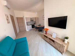 a living room with a blue couch and a flat screen tv at MESSAPIA HOME Apartments in Mesagne