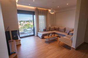 a living room with a couch and a tv at CASA UNO Horizon in Platamonas