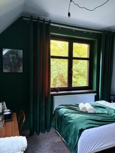 a green bedroom with a bed and a window at La Melodia in Kościerzyna